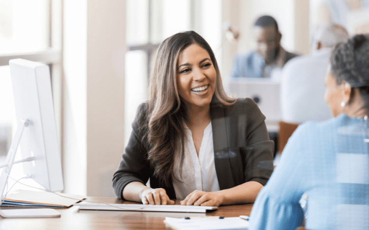 Twin Cities accounting and payroll expert talks with a small business owner at an office desk