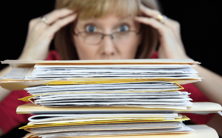 Business owner woman wants to file big stack of paper several years of back taxes at the same time