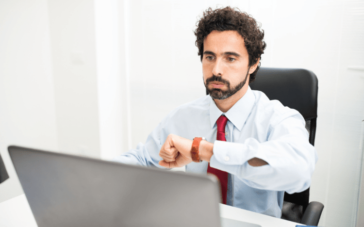 Small business owner checking his watch about the timeline for his monthly accounting to get done