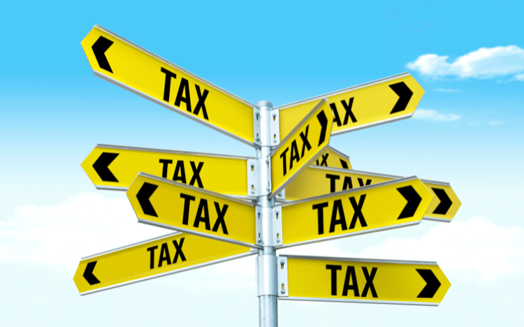 A road sign with several directions labeled "Tax"