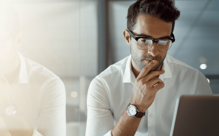 Small business owner looking at computer wondering if CSI will let him handle some of his own accounting and payroll