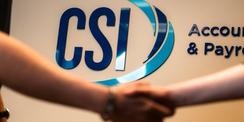 Shaking hands in front of CSI sign